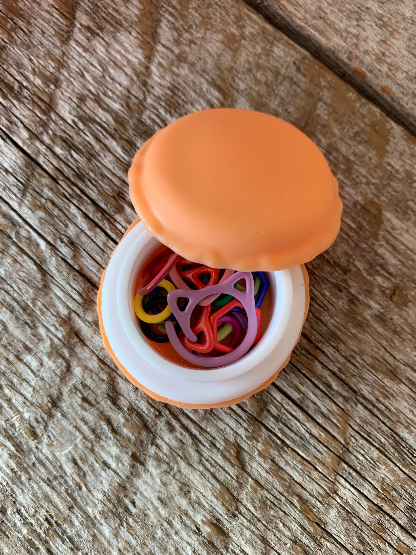 Marqueurs de mailles variés en métal dans un contenant macaron