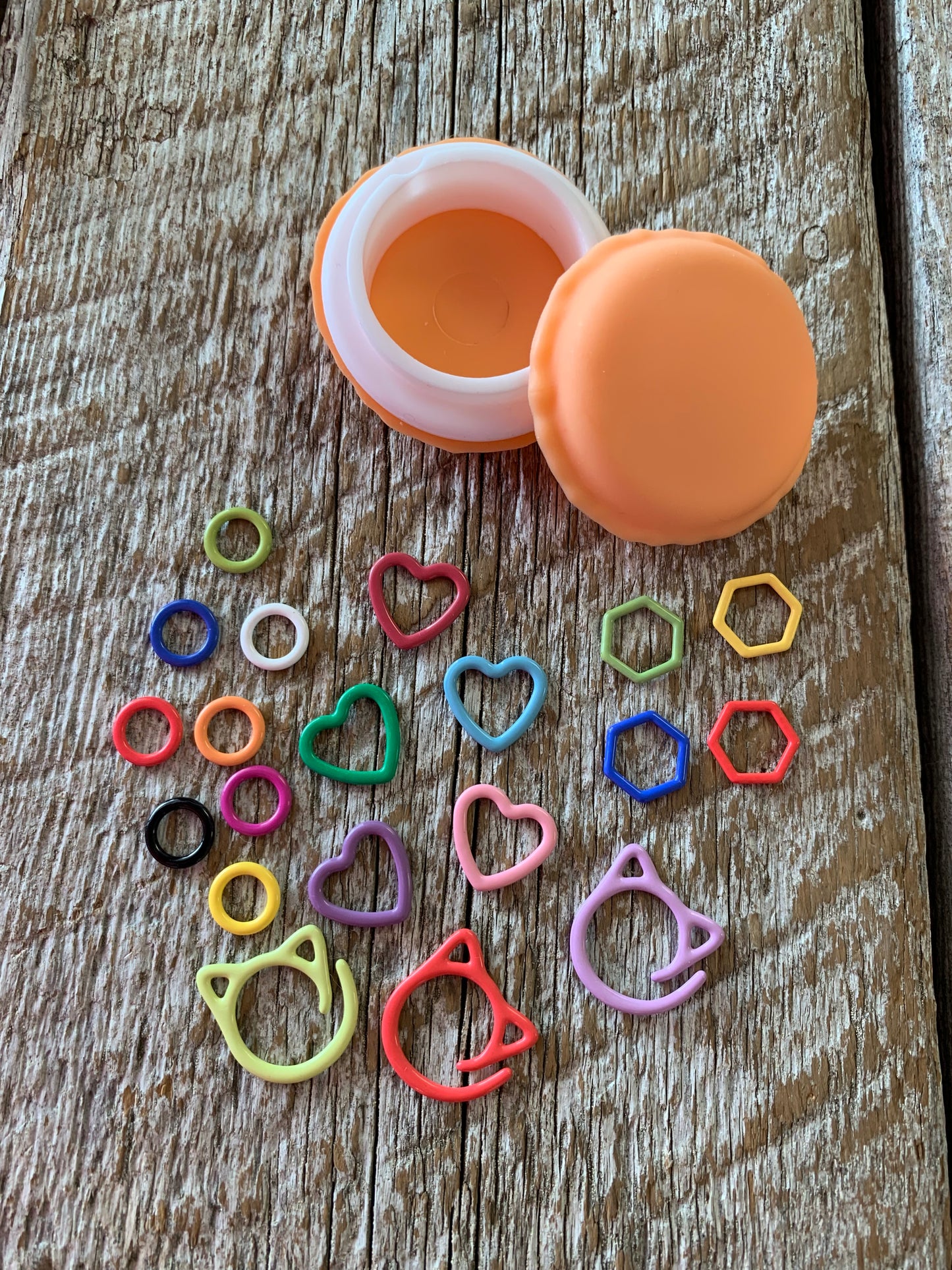 Marqueurs de mailles variés en métal dans un contenant macaron